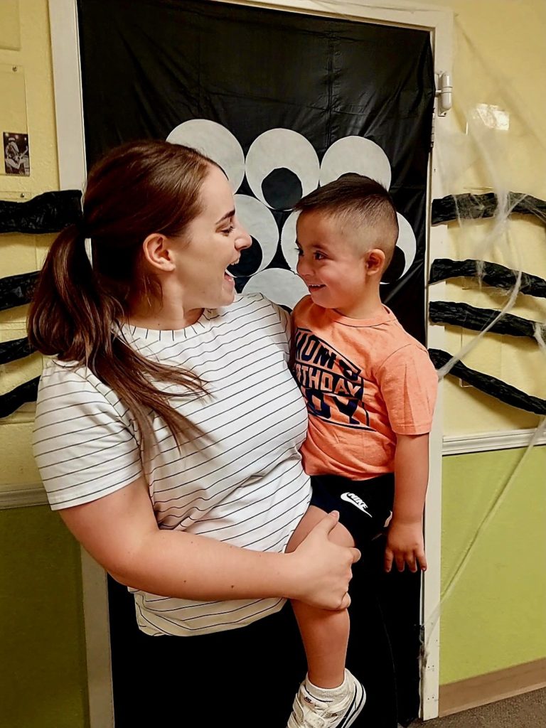 CTC therapist holding a young patient and the two are giggling at each other